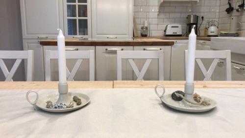 zwei Kerzen auf einem Tisch in einer Küche in der Unterkunft Lütt Reethuus in Fehmarn