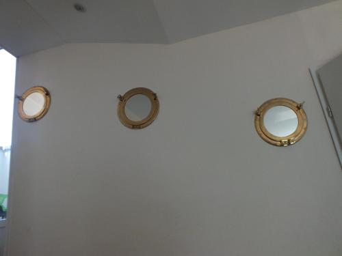 two mirrors on a white wall in a bathroom at Residence Miranto in Châteauroux