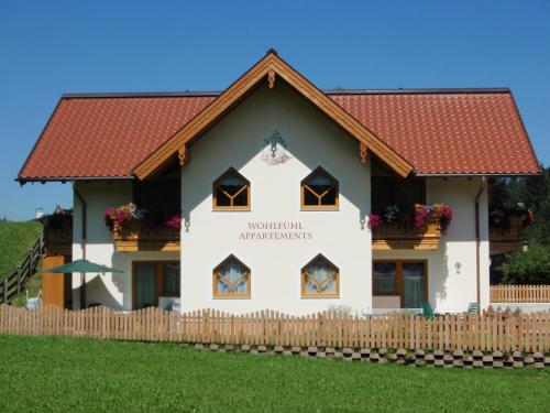 a house with a red roof and a fence at Flachauer Bergkristall in Flachau