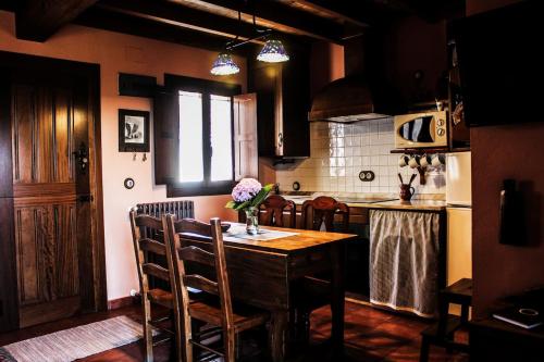 cocina con mesa de madera con sillas y barra en Alto el Monte 1 - AR1414, en Luanco