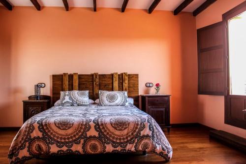 una camera con un letto in una stanza con pareti arancioni di Alto el Monte 1 - AR1414 a Luanco