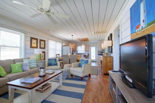 a living room with a large flat screen tv at Magnolia Cottage in Holden Beach