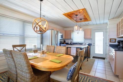 a kitchen and dining room with a wooden table and chairs at Magnolia Cottage in Holden Beach