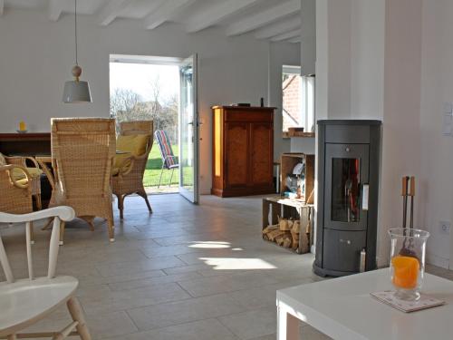 a living room with a fireplace and a table and chairs at Ferienhaus Domizil Wattenmeer in Friedrichskoog