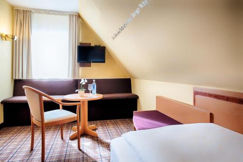 a hotel room with a small table and a bed at Welcome Hotel Legden in Legden