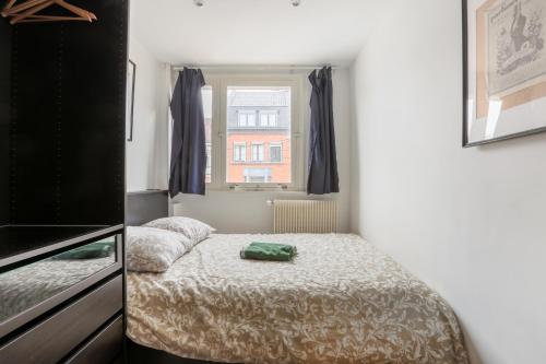 a small room with a bed and a window at Appartement Croisé Laroche 40m2 in Marcq-en-Baroeul