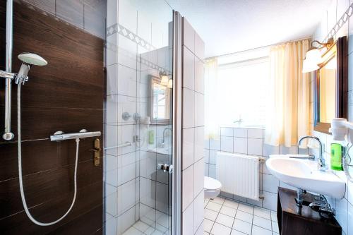 een badkamer met een douche, een wastafel en een toilet bij Welcome Hotel Legden in Legden