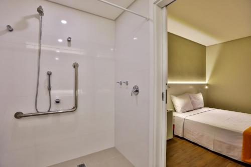 a small bathroom with a bed and a shower at Transamerica Fit Serra in Serra