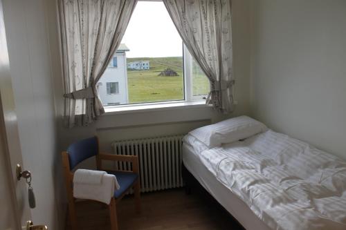 Habitación pequeña con cama y ventana en The Nest en Raufarhöfn