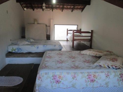 a bedroom with two beds in a room at Aldeia Itamambuca Chalé Camping Ubatuba in Ubatuba