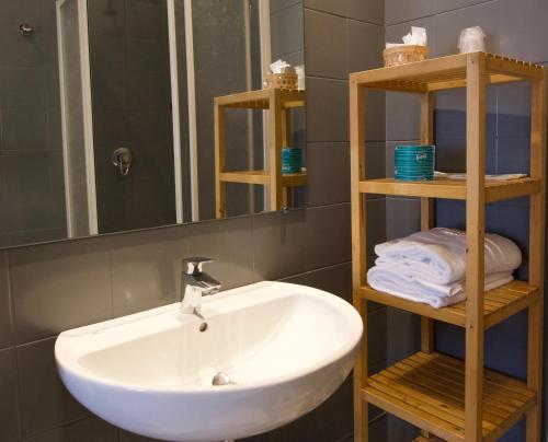 y baño con lavabo, espejo y toallas. en Locanda le Monache, en Camaiore