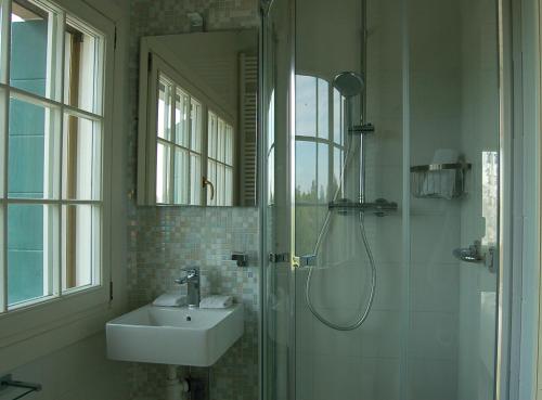 W łazience znajduje się umywalka oraz prysznic ze zlewem. w obiekcie Junior Suites Venezia w Wenecji
