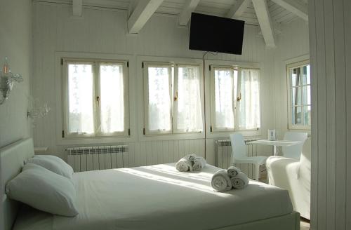 a white bedroom with a bed with towels on it at Junior Suites Venezia in Venice