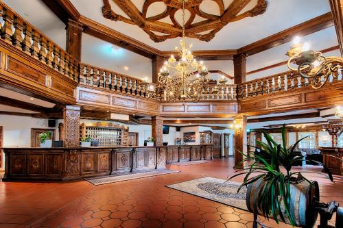 a large lobby with a chandelier and wooden walls at Welcome Hotel Legden in Legden
