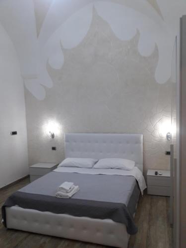 een witte slaapkamer met een bed en 2 verlichting bij SOLE E LUNA in Taranto