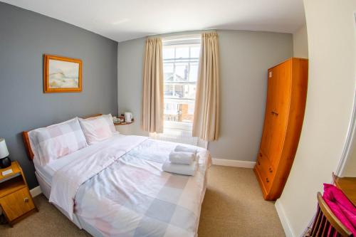um quarto com uma cama grande e uma janela em Olivers Guest House em Weymouth
