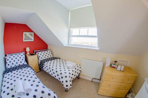 a bedroom with two beds and a window at Olivers Guest House in Weymouth