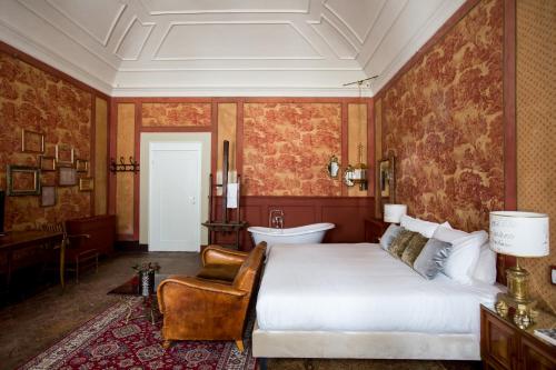 a bedroom with a bed and a chair and a tub at Oltrarno Splendid in Florence