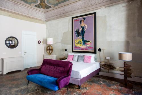 a bedroom with a king sized bed and a purple chair at Oltrarno Splendid in Florence