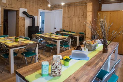 een kamer met houten tafels en stoelen en een fornuis bij Riversong Centre Thermal in Les Plans-sur-Bex