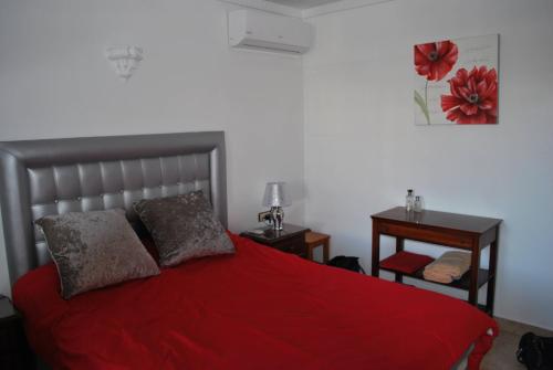a bedroom with a red bed with two night stands at Casa Grace Naturist Apartment Vera in Vera