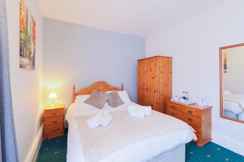a bedroom with a bed with two towels on it at The Clee Hotel - Cleethorpes, Grimsby, Lincolnshire in Cleethorpes