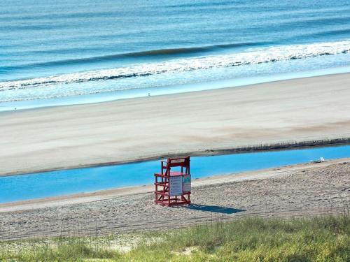 a red lifeguard chair sitting on a beach at Amelia Island Oceanfront 2 Master Suites in Amelia Island