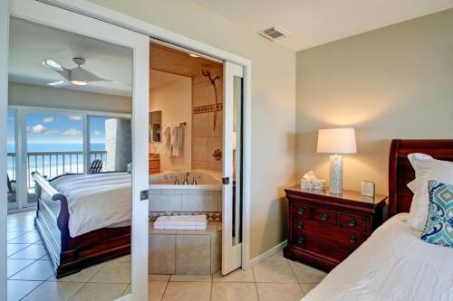 a bedroom with a bed and a tub with a window at Amelia Island Oceanfront 2 Master Suites in Amelia Island