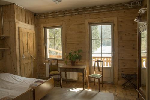 a bedroom with a bed and a table and chairs at Riversong Centre Thermal in Les Plans-sur-Bex