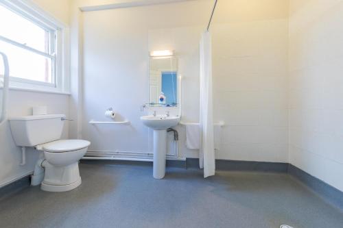 a white bathroom with a toilet and a sink at The Clee Hotel - Cleethorpes, Grimsby, Lincolnshire in Cleethorpes