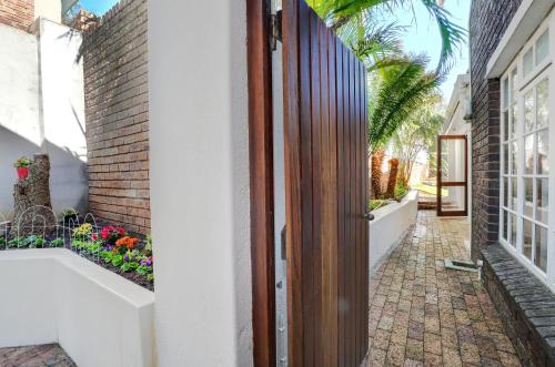 an entrance to a house with a courtyard with flowers at Mountain Rose Cottage in Bellville