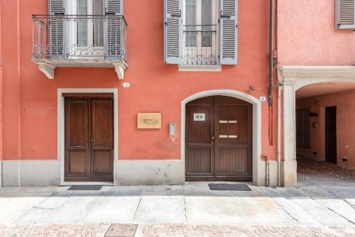 two doors on the side of a pink building at trifulhouse holiday apartments in Alba