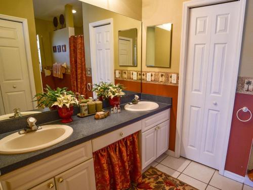 a bathroom with two sinks and a large mirror at Gulf Retreat 2: Magnificent Water Views, Steps to Beach, None Cleaner, None Nicer! in Clearwater Beach