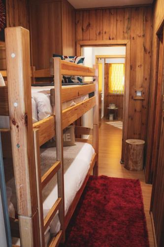 a room with two bunk beds and a red rug at Casinha dos Relógios in Penhas da Saúde