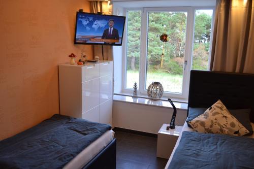 Cette chambre dispose d'une télévision, d'un lit et d'une fenêtre. dans l'établissement Arkona-Meeresblick am Prorer Wiek, à Binz