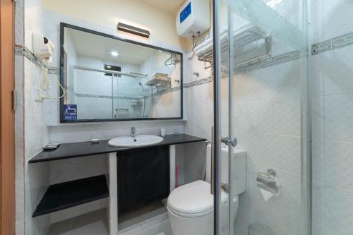 bagno con lavandino, servizi igienici e specchio di Paguro Beach Inn a Ukulhas