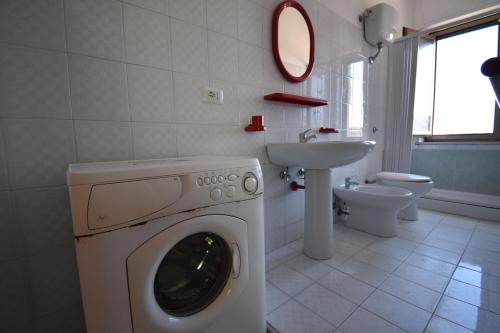 une salle de bains avec lave-linge et lavabo dans l'établissement Residence On The Beach, à Vasto