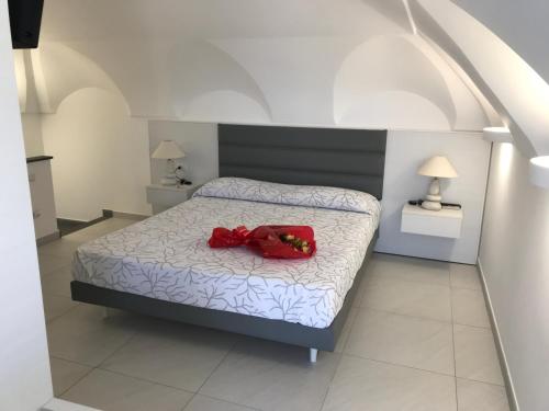 a bedroom with a bed with a red item on it at Vento di mare in Procida