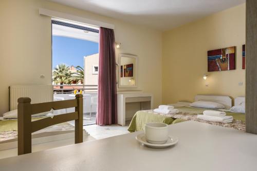 a room with a bed and a table and a window at Ariadne Hotel in Platanes