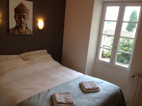 une chambre avec un lit avec deux serviettes dessus dans l'établissement Gîte Le Bonheur, à Hiersac