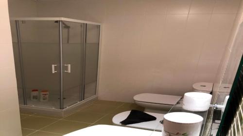 La salle de bains est pourvue de toilettes et d'une douche en verre. dans l'établissement Impresionante alojamiento compuesto por 2 Chalets Adosados de lujo para 14 personas Piscina con CIRCUITO SPA, à Sant Jordi