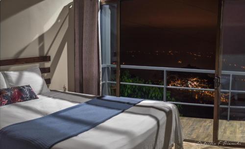 a bed in front of a window with a view at Casa Linda Vista in Caño Seco