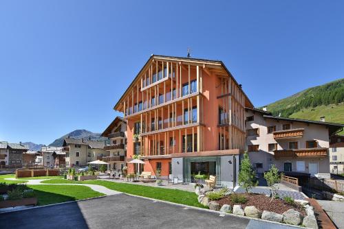 a large building with a lawn in front of it at Hotel Roberta Alpine Adults only in Livigno