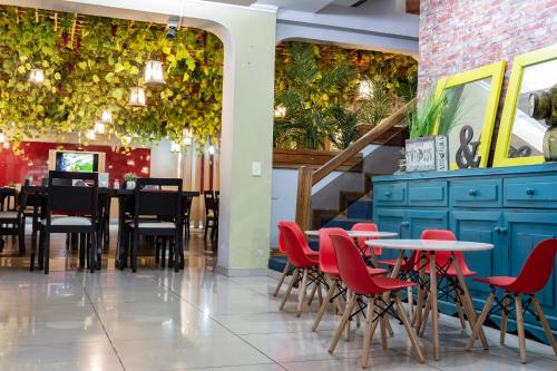 a dining room with red chairs and tables in a restaurant at Los Alpes Santa Teresa in Asuncion