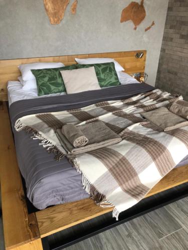 - un lit en bois avec des couvertures et des oreillers dans l'établissement Красная поляна, улица Турчинского 85, à Krasnaïa Poliana