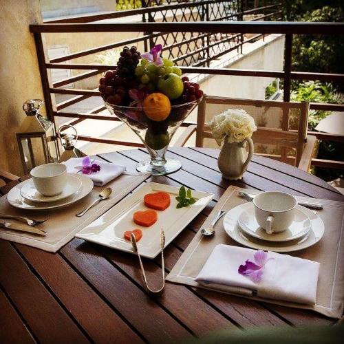 a table with a plate of fruit and a bowl of fruit at Abayomi Hotel in Ilhabela