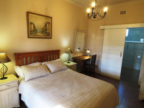 a bedroom with a bed and a table and a desk at Gansbaai Central Accommodation Sleeps 2 adults and 2 kids under 10 years in Gansbaai