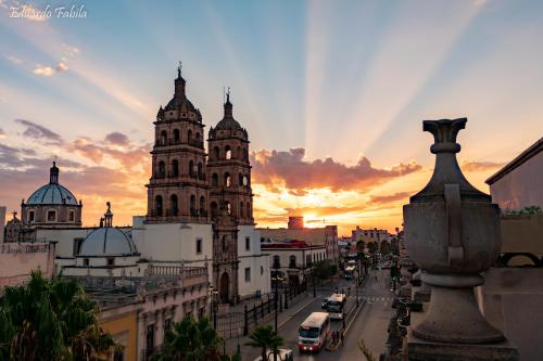 a view of a building with a sunset in the background at Hotel Roma in Durango