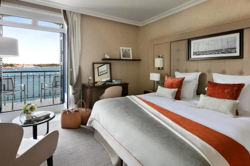 a hotel room with a large bed and a large window at Hôtel Barrière Le Grand Hôtel Dinard in Dinard