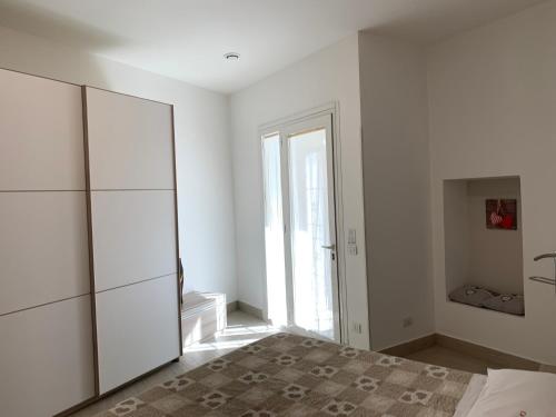a white bedroom with a bed and a large window at CA FOSCARI Apartments San Siro in Milan